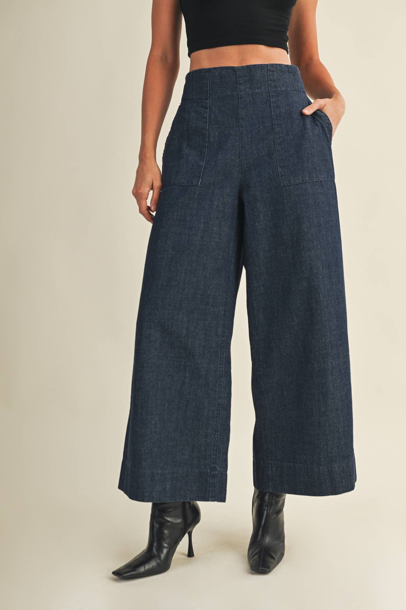 High-waisted denim trousers styled with ankle boots.