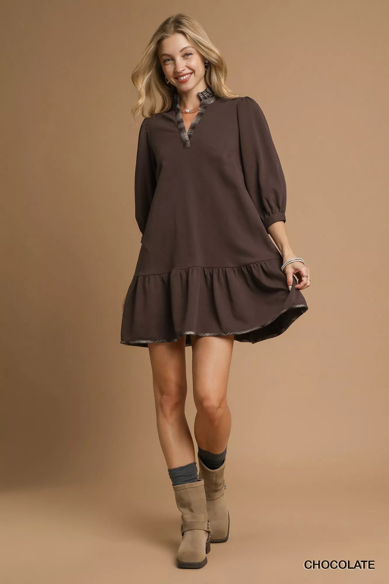 Brown long-sleeve dress styled with gold jewelry.